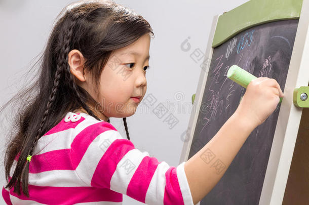 孩子在黑板背景上写字/孩子在黑板上写字/孩子在白色背景上在黑板上写字