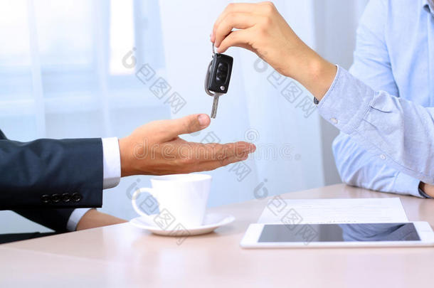 汽车<strong>推销</strong>员把新车的钥匙交给一个年轻的商人