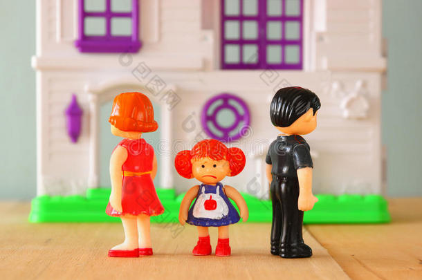 家长忙碌或愤怒的概念形象，孩子在前面的中间。 小塑料玩具娃娃（男、女、儿童）