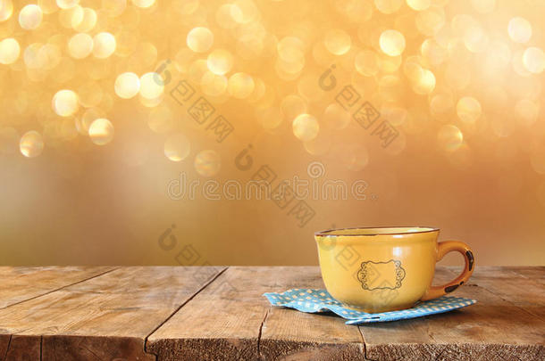 咖啡杯在木桌上的正面形象和森林背景前的秋叶。 复古风格的形象