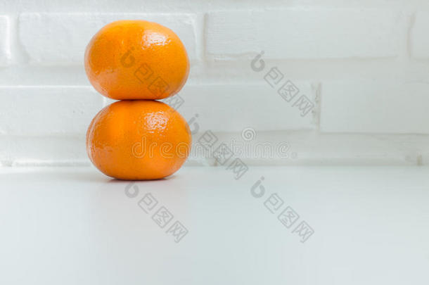 白色桌子上有白色砖块背景的新鲜橘子