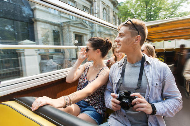 一对带着相机的微笑情侣乘坐旅游巴士旅行