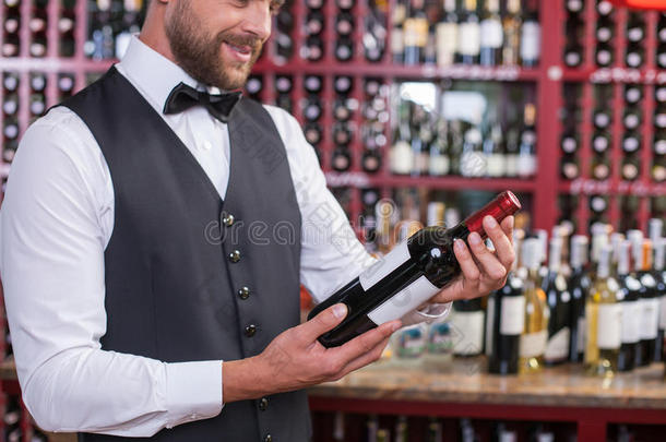 有吸引力的男服务员正在酒类商店工作