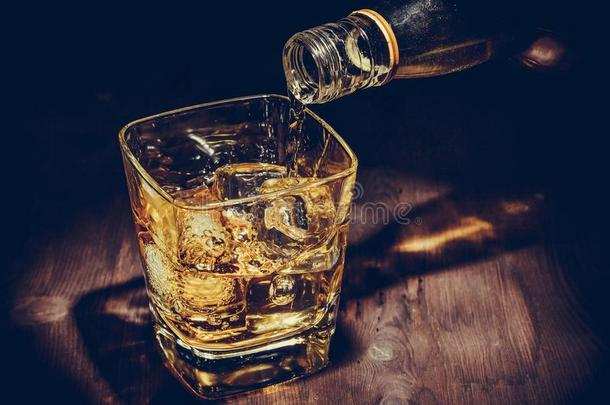 酒保将威士忌倒在木桌上的玻璃上，气氛热烈，古色古香