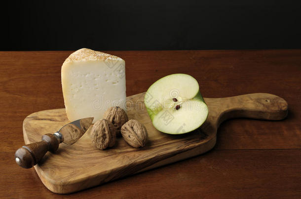 带奶酪和绿色苹果的切割板