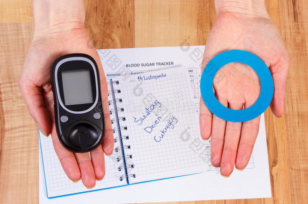血糖仪和蓝色圆圈在手，象征<strong>糖尿病</strong>，世界<strong>糖尿病日</strong>