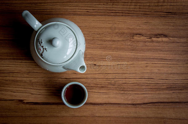 一杯茶和一壶水壶，背景是乡村的木头