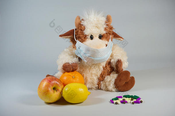 儿童玩具公牛在医疗面具与健康的水果和VA