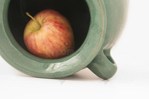近景的红色苹果在绿色的土罐里
