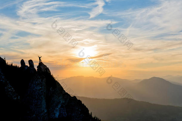 日落时登山者在山顶上