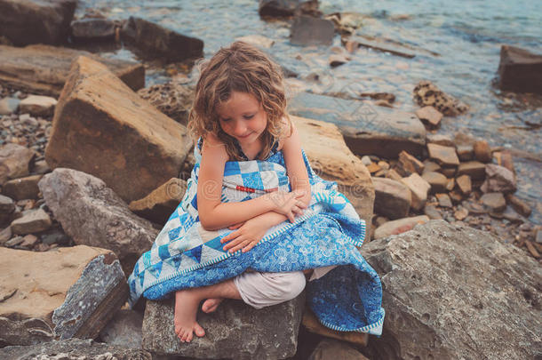 小女孩<strong>盖</strong>着<strong>被子</strong>毯子，在海边度过舒适的暑假