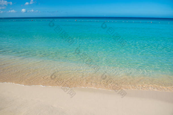 蔚蓝的绿松石平静的大海，清澈的蓝天，沙滩和平坦的地平线
