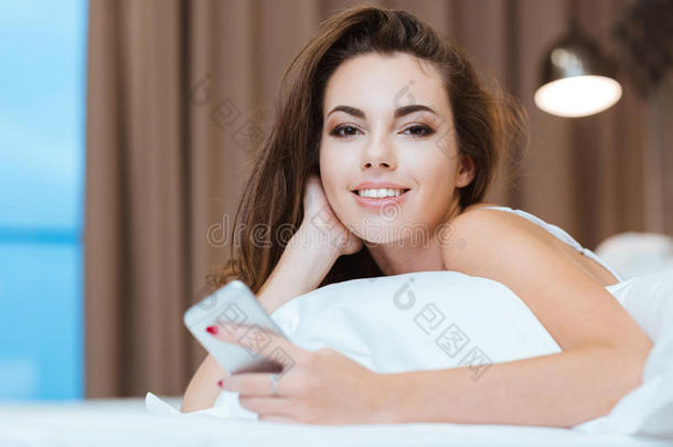 女人躺在床上拿着智能手机