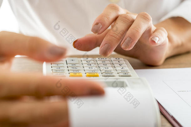 女银行家使用加法机计算费用和收入