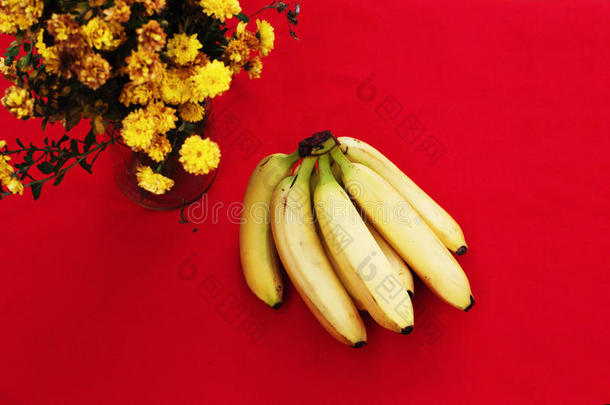 红色背景上的一堆<strong>香蕉</strong>。 新鲜有机<strong>香蕉</strong>，厨房桌子上的新鲜<strong>香蕉</strong>