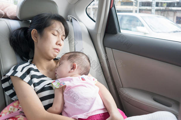 亚洲母亲和婴儿睡在街上的车里。