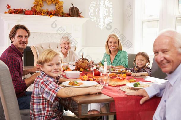 家人和祖父母在餐桌上享用感恩节大餐