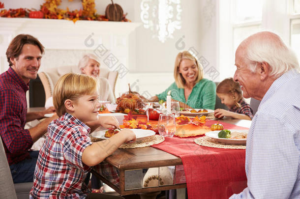 家人和祖父母在餐桌上享用感恩节大餐
