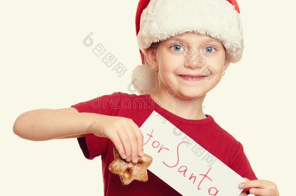 戴着圣诞老人帽子的女孩带着饼干-寒假圣诞节的概念