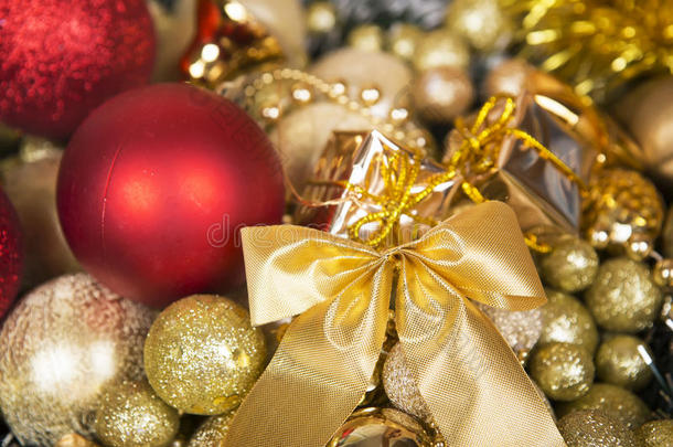 圣诞红球和金色背景上的蝴蝶结。