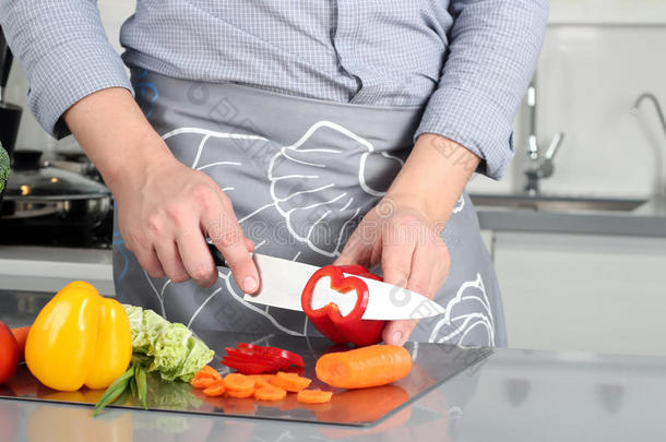 食物，家庭，烹饪和人的概念-男人在砧板上用刀子在厨房里切辣椒