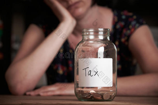 沮丧的女人看着空罐子贴上<strong>税收</strong>标签