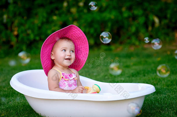 漂亮的<strong>小女孩</strong>戴着夏天的粉红色帽子<strong>洗澡</strong>