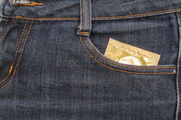 牛仔裤口袋里的避孕套。 背景。