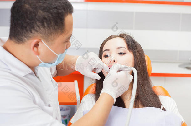 牙医医生在牙科办公室治疗牙齿病人女孩