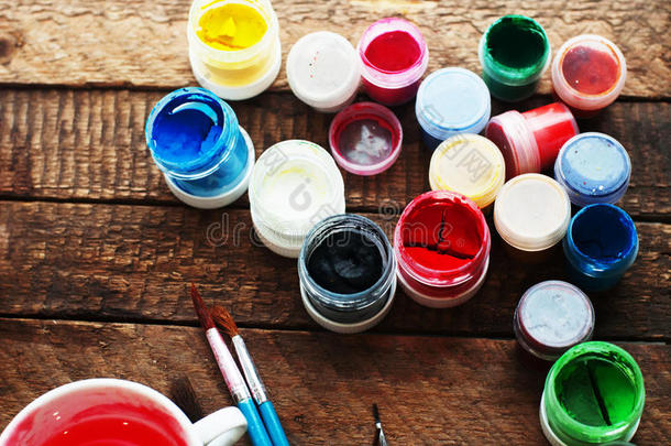 绘画艺术。 油漆桶在木材背景上。 不同的油漆颜色在木制背景上绘画。 绘画集：刷子，爸爸