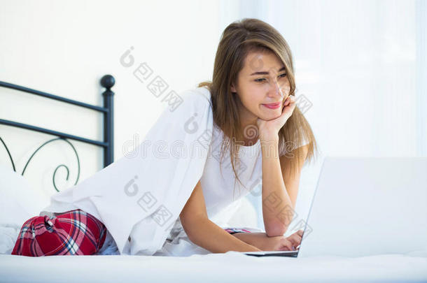 开朗的学生女孩在床上<strong>学习笔记</strong>本电脑