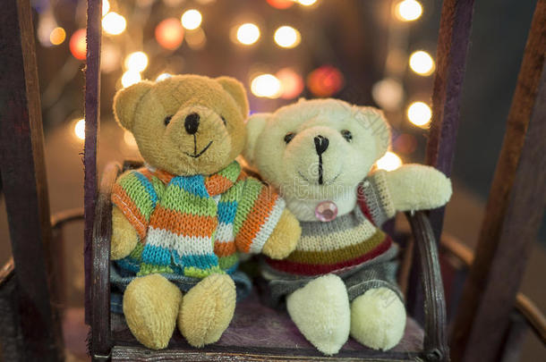 <strong>可爱</strong>的两只<strong>娃娃</strong>熊。 一对<strong>可爱</strong>的泰迪熊坐在木摆上，背景是波克光。 泰迪熊穿冬天的套房。 拥抱