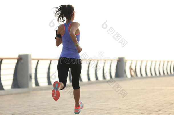 健身女子跑步者在海边跑步