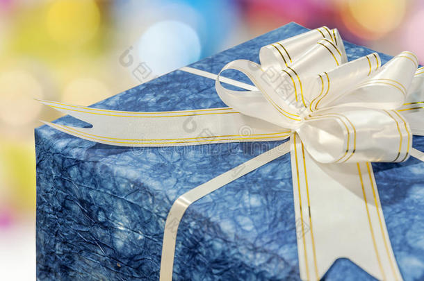 蓝色礼品盒，白色和金色丝带和蝴蝶结