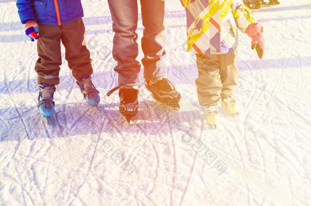 父亲和孩子们在冬天滑冰，家庭冬天