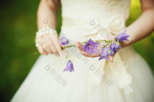 美丽的新娘穿着豪华的婚纱，紫色的薰衣草