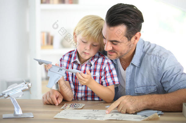 父亲和孩子在建造一个飞机玩具
