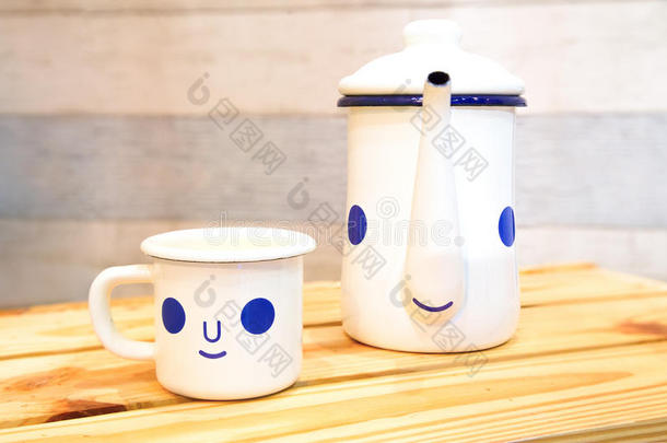 卡通水壶和咖啡杯，在木桌上笑得很开心。