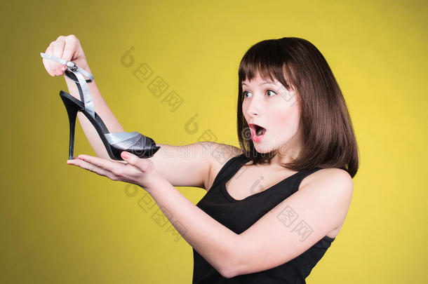 时尚女人看<strong>高跟鞋</strong>。 女人喜欢鞋子的概念。 尖叫的女孩和黄色背景的<strong>高跟鞋</strong>。 太棒了