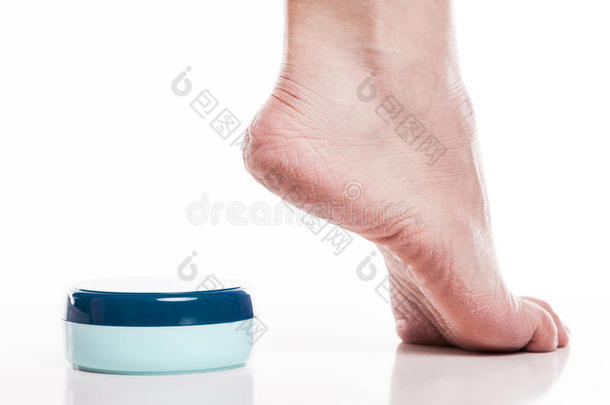 护理干净的脚和高跟鞋上的干燥皮肤与奶油