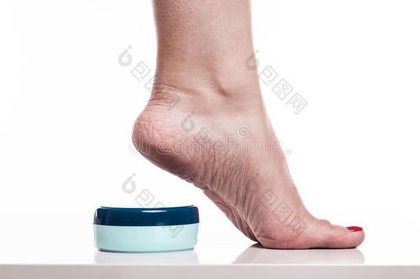 护理干净的脚和高跟鞋上的干燥皮肤与奶油