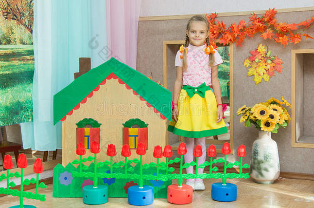一个女孩站在幼儿园日场上的风景屋
