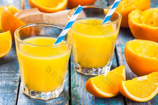 用<strong>吸管</strong>在玻璃<strong>杯</strong>里新鲜榨橙汁