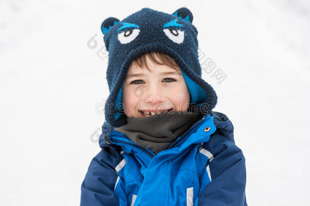 一个穿着温暖冬天衣服的孩子在雪地背景上的肖像