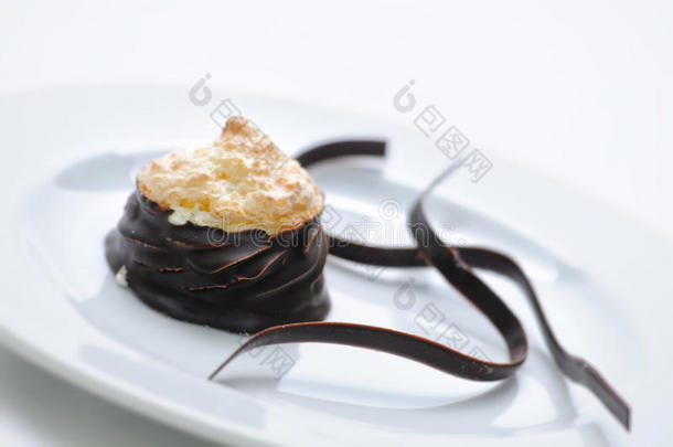 巧克力蛋糕与椰子和巧克力漩涡白色盘子，甜甜点与巧克力，糕点，摄影为商店