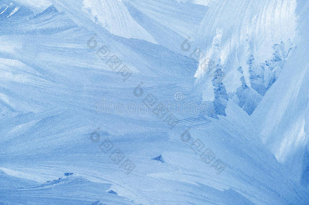 冬天窗户玻璃上的霜花图案。 磨砂玻璃质地。 蓝色