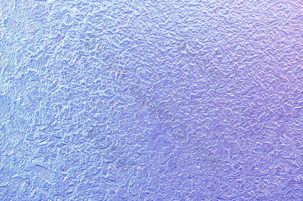 冬天窗户玻璃上的霜花图案。 磨砂玻璃质地。 蓝色和紫色