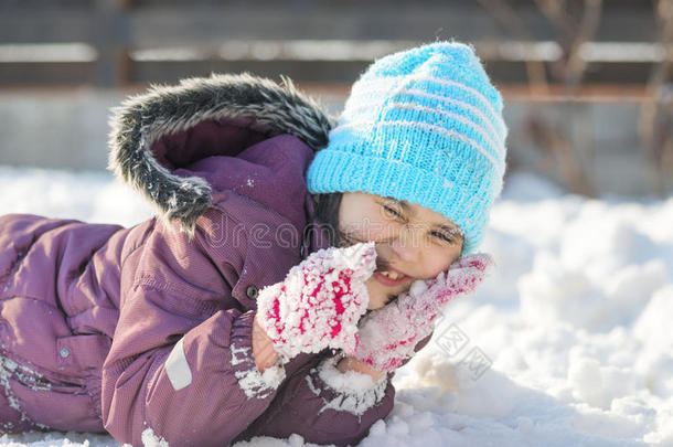 有趣的小女孩在美丽的冬天公园里下雪