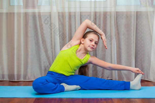 健身。 运动，训练和生活方式的概念-孩子在家里做垫子上的练习。