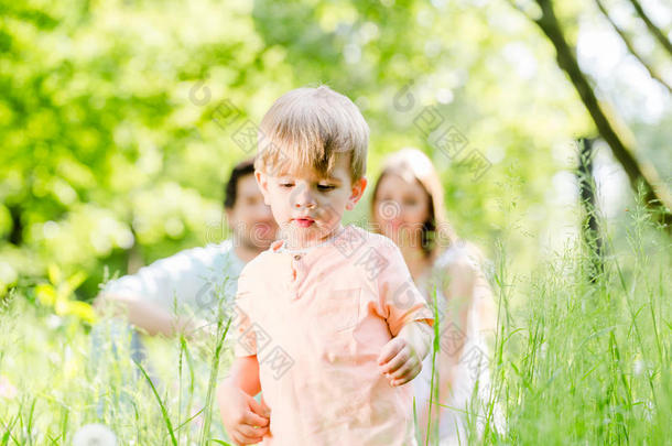 男孩和家人在草地上跑步和玩耍